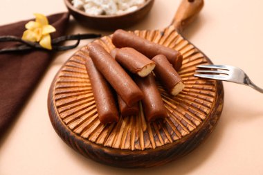 Bir kase kaymak, çatal ve yiyecek ve bej arka planda lezzetli süzme peynirli barlar.