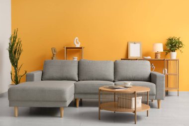 Rahat bir kanepe, kahve masası ve şık bir oturma odasında çiçek.