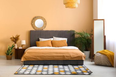 Sıcak yatak, ayna ve lamba güzel yatak odasındaki komodinin üzerinde.