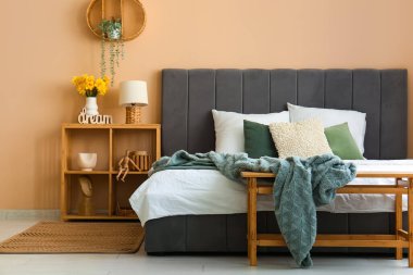 Şık yatak, raf ünitesi ve lamba yatak odasında.