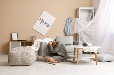 Evdeki deprem sırasında halıda oturan kadın.