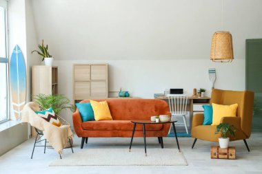 İçinde kanepe, sandalye ve sörf tahtası olan modern bir oturma odası.