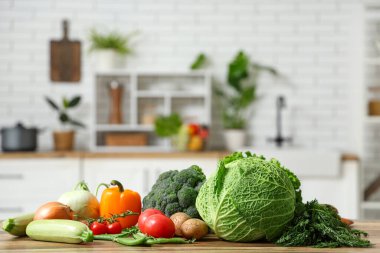 Ahşap mutfak tezgahında farklı taze sebzeler.