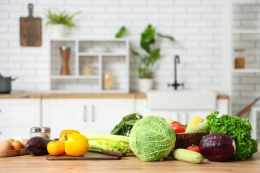 Ahşap mutfak tezgahında farklı taze sebzeler.