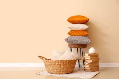 Sandalyede bir yığın yumuşak yastık ve şık bir odada kitaplar.