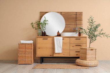 Göğüs, lavabo ve ayna dolu hafif bir banyo.