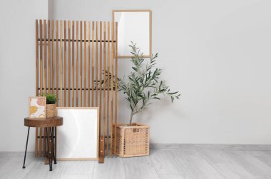 Zeytin ağacı, sehpa, resim ve katlanır ekran olan bir oturma odası.