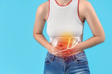 Açık mavi arka planda karaciğer ağrısı çeken genç bir kadın.