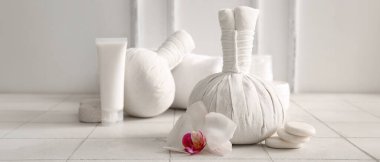 Bitki torbası, spa taşları ve arka planda orkide çiçeği.