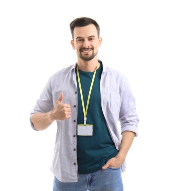 Boş rozetli genç adam beyaz arka planda baş parmağını gösteriyor.