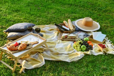 Romantik pikniğe hazır lezzetli yemekler ve şarap yeşil çimen arka planda kumsalda
