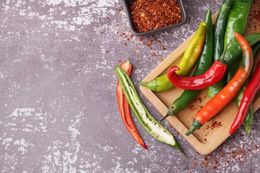 Taze biberli ahşap tahta tahta ve koyu arkaplanda kurutulmuş baharatlar.