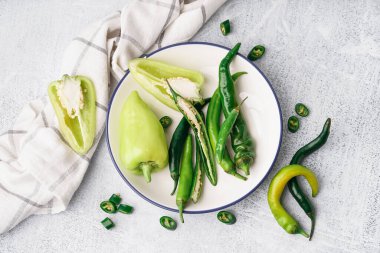 Beyaz arka planda farklı taze biberli tabak.