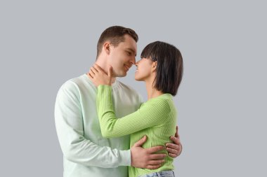 Genç aşıklar arka planda sarılıyorlar.