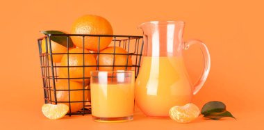 Turuncu arka planda taze mandalina suyu.