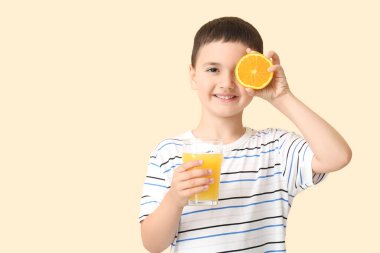 Turuncu ve bej arka planda bir bardak meyve suyu olan şirin bir çocuk.