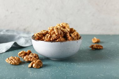 Masanın üzerinde beyaz duvara karşı bir kase lezzetli ceviz