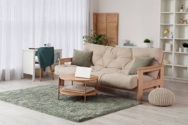 Rahat kanepesi, sehpası ve raf ünitesi olan bir oturma odası.