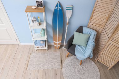 Gri koltuklu ve sörf tahtalı şık bir oturma odası.