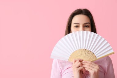 Pembe arka planda beyaz elli güzel bir kadın.