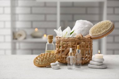 Yağ şişeleri, spa taşları, mum ve hasır sepet.