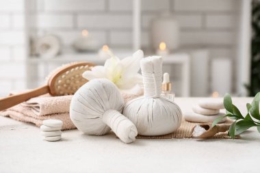 Bitki torbaları, spa taşları ve banyo malzemeleri ile güzel bir kompozisyon.