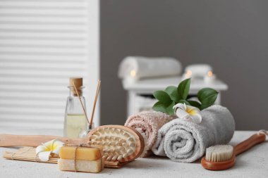 Havlular, sabunluklar, masaj vücut fırçaları ve banyo tesisatı olan güzel bir kompozisyon, yakın plan.