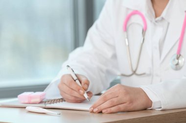 Ahşap masada çalışan kadın doktor, yakın plan.