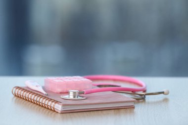 Defter, steteskop, haplar ve steteskop ahşap masada.