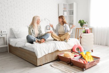 Anne ve kızı yatakta oturup yatak odasında bir şey tartışıyorlar. Seyahat kavramı