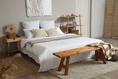 Rahat bir yatak ve yatak odasının içinde resimler.