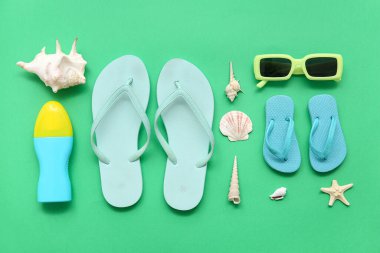 Terlikli kompozisyon, güneş kremi ve yeşil arka planda deniz kabukları