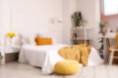 Açık renk yatak odası, rahat yatak odası ve sarı narsisli çiçekler.