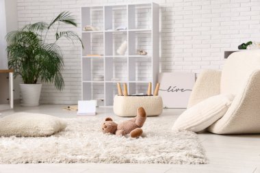 Oyuncak ayı pasaklı oturma odasında halıda