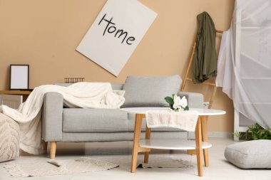 İçinde kanepe ve ters dönmüş saksı olan dağınık bir oturma odası.