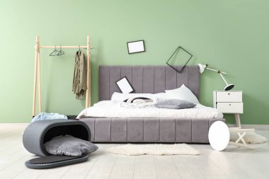 Çerçeveli ve elbise askılı dağınık bir yatak odası.