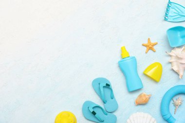 Mavi arka plandaki çocuklar için güneş kremi ve plaj aksesuarlarıyla güzel bir kompozisyon