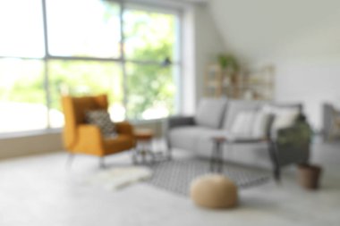 Bulanık oturma odası, gri kanepe, koltuk ve puf.