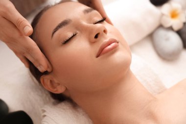 Kaplıca salonunda masaj yaptıran genç bir kadın, yakın plan.