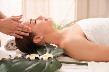 Kaplıca salonunda masaj yaptıran genç bir kadın, yakın plan.