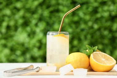 Dışarıdaki beyaz ahşap masada naneli bir bardak taze limonata.