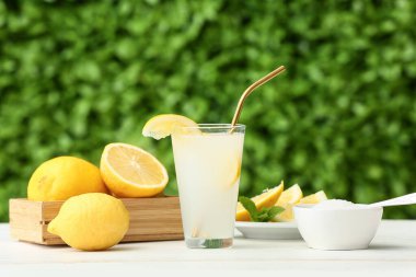 Dışarıdaki beyaz ahşap masada naneli bir bardak taze limonata.