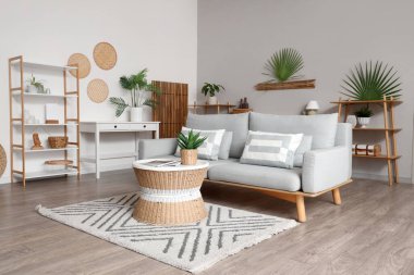 Oturma odasında kanepe, masa ve raf üniteleri var.