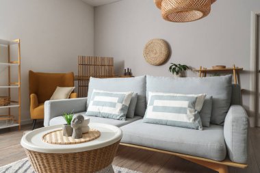 Oturma odasının içinde kanepe, masa ve koltuk var.