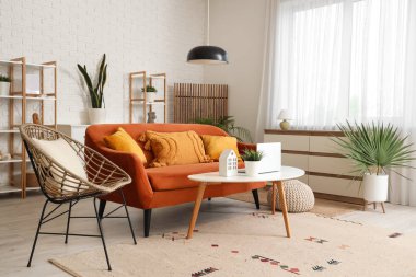 Oturma odasının içi kırmızı kanepe, koltuk ve ahşap perdeli.