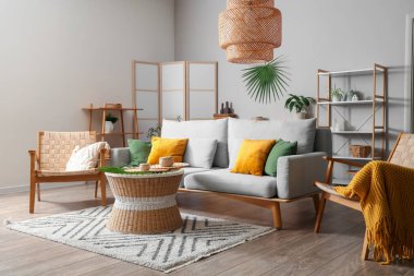 Oturma odasının içinde kanepe, koltuk ve katlanır ekran var.