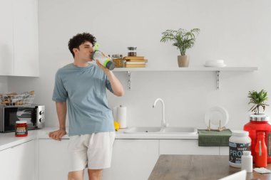 Protein içeceği mutfakta içme sportif genç adam