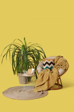 Masalı koltuk, palmiye ağacı ve sarı arka planda halı.
