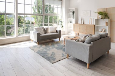 Koltukları, çekmeceleri ve tabloları olan şık bir oturma odası.