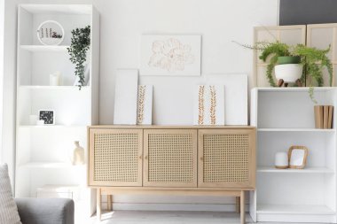 Raf üniteleri, tuvalet ve resimlerle aydınlık oturma odasının içinde.